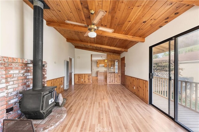 14526 Hardtree Dr, Lake Hughes, CA 93532 - unfurnished living room featuring a wainscoted wall, a wood stove, wood walls, light wood finished floors, and wooden ceiling