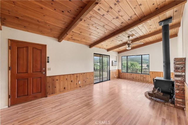 14526 Hardtree Dr, Lake Hughes, CA 93532 - unfurnished living room with a wainscoted wall, a wood stove, wood walls, wood finished floors, and wooden ceiling