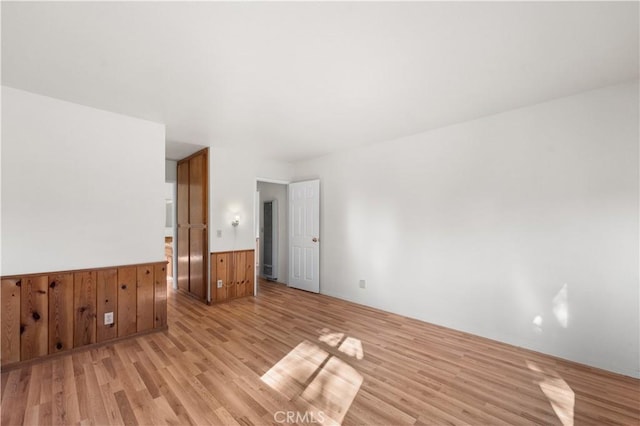 14526 Hardtree Dr, Lake Hughes, CA 93532 - unfurnished room featuring light wood-style floors, a wainscoted wall, and wood walls