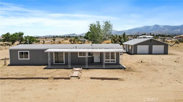 4369 Amador Rd, Phelan, CA 92371 - back of property featuring a detached garage, a mountain view, and a patio area