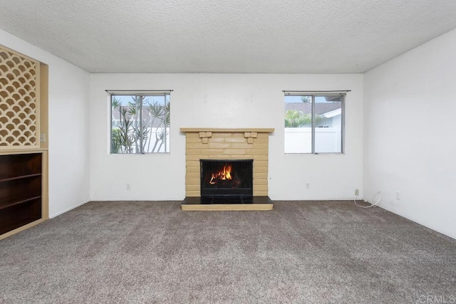 1608 Grandview St, Oceanside, CA 92054 - unfurnished living room featuring a textured ceiling, carpet, a lit fireplace, and plenty of natural light