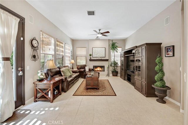 28089 Promontory Ln, Valencia, CA 91354 - living room featuring plenty of natural light, a ceiling fan, light tile patterned floors, and a warm lit fireplace