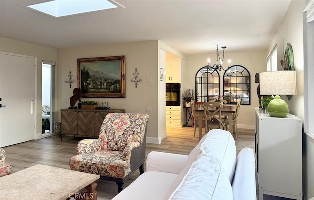 2148 Ronda Granada Unit A, Laguna Woods, CA 92637 - living room featuring a chandelier, light wood-style floors, and a skylight