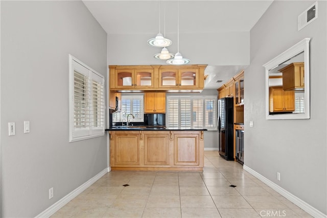 3211 Anne Cir Unit Ci102, Huntington Beach, CA 92649 - kitchen with freestanding refrigerator, light tile patterned floors, dark countertops, and glass insert cabinets