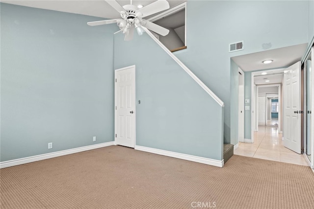 3211 Anne Cir Unit Ci102, Huntington Beach, CA 92649 - empty room featuring light colored carpet, ceiling fan, a high ceiling, and stairs