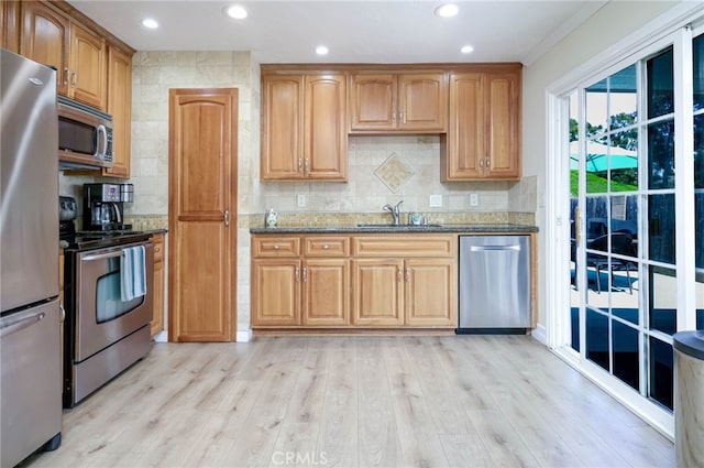 19851 Ridgewood Pl, Yorba Linda, CA 92886 - kitchen featuring appliances with stainless steel finishes, dark stone countertops, backsplash, light wood-type flooring, and crown molding