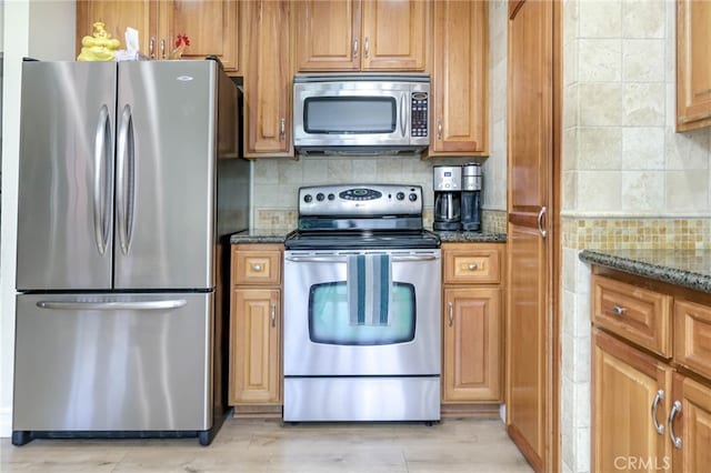 19851 Ridgewood Pl, Yorba Linda, CA 92886 - kitchen with appliances with stainless steel finishes, dark stone countertops, backsplash, and light wood-type flooring