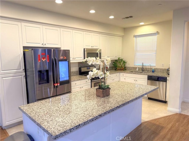 867 E Prommenade Unit B, Azusa, CA 91702 - kitchen featuring stainless steel appliances, white cabinets, light stone countertops, a center island, and recessed lighting