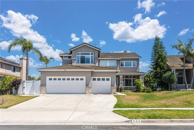 982 Big Spring Ct, Corona, CA 92878 - view of front of home with stone siding, stucco siding, a gate, driveway, and a porch