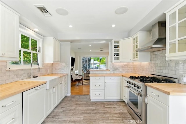 5517 Bevis Ave, Sherman Oaks, CA 91411 - kitchen with wall chimney range hood, high end range, wood counters, healthy amount of natural light, and recessed lighting