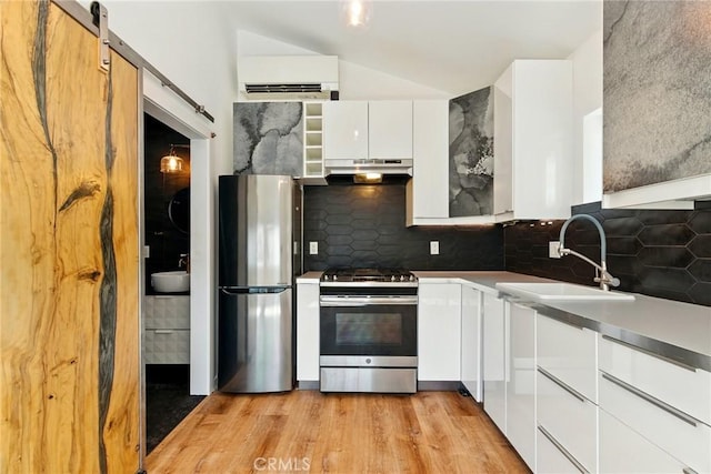 5517 Bevis Ave, Sherman Oaks, CA 91411 - kitchen featuring appliances with stainless steel finishes, under cabinet range hood, modern cabinets, white cabinetry, and light wood finished floors
