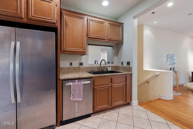 1430 Windshore Way, Oxnard, CA 93035 - kitchen with appliances with stainless steel finishes, brown cabinetry, light tile patterned flooring, recessed lighting, and light stone counters