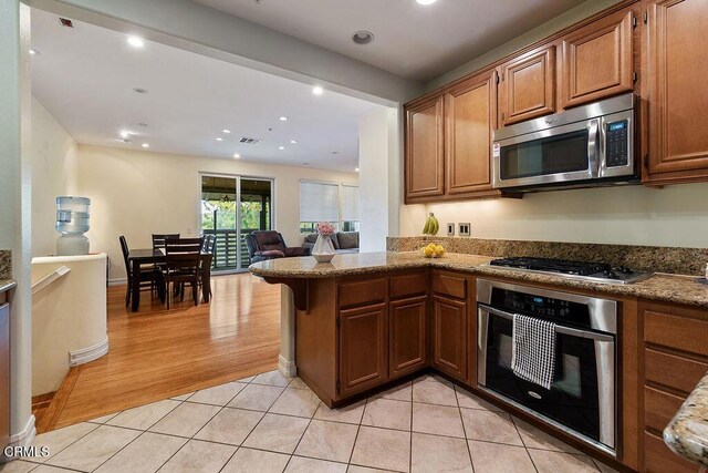 1430 Windshore Way, Oxnard, CA 93035 - kitchen featuring stainless steel appliances, a peninsula, brown cabinetry, open floor plan, and recessed lighting