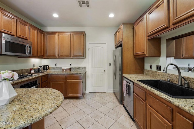 1430 Windshore Way, Oxnard, CA 93035 - kitchen with appliances with stainless steel finishes, light tile patterned floors, recessed lighting, light stone counters, and brown cabinetry