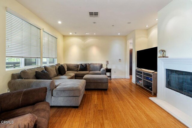 1430 Windshore Way, Oxnard, CA 93035 - living area with light wood-style floors, a glass covered fireplace, and recessed lighting