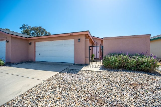158 Colt Ln, Nipomo, CA 93444 - view of front facade with stucco siding, a garage, driveway, and a gate