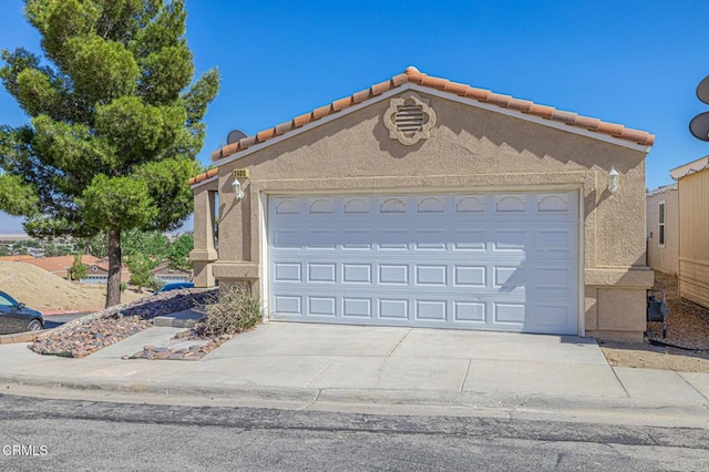 2400 Sunset Ridge Dr, Rosamond, CA 93560 - view of front of home with stucco siding, concrete driveway, a garage, and a tiled roof