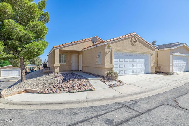 2400 Sunset Ridge Dr, Rosamond, CA 93560 - view of front facade with an attached garage, stucco siding, a tiled roof, and driveway