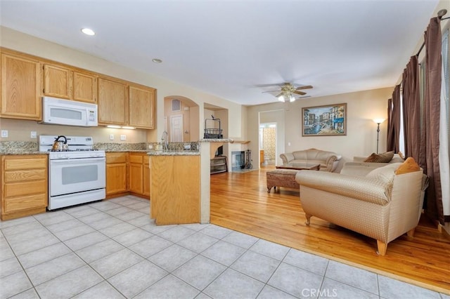 13524 Via Santa Catalina, Sylmar, CA 91342 - kitchen featuring white appliances, a peninsula, open floor plan, light tile patterned floors, and arched walkways