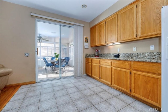 13524 Via Santa Catalina, Sylmar, CA 91342 - kitchen featuring light stone counters, ceiling fan, and brown cabinetry