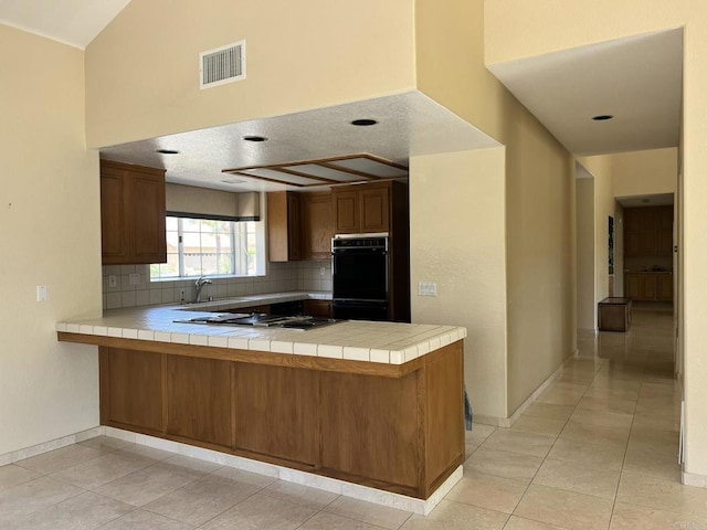 14109 Arbolitos Dr, Poway, CA 92064 - kitchen with cooktop, a peninsula, tasteful backsplash, and tile countertops