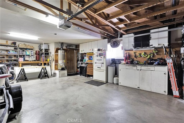 14616 Lighthouse Ln, Helendale, CA 92342 - garage featuring freestanding refrigerator, a garage door opener, a workshop area, and secured water heater