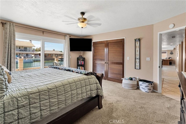 14616 Lighthouse Ln, Helendale, CA 92342 - bedroom featuring a closet, a textured ceiling, light carpet, a ceiling fan, and light tile patterned flooring