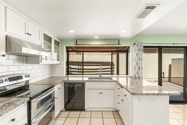 31 Pebblewood Pines Dr, Chico, CA 95926 - kitchen featuring black dishwasher, double oven range, under cabinet range hood, light tile patterned flooring, and a peninsula
