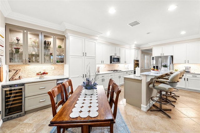 32872 Northshire Cir, Temecula, CA 92592 - kitchen featuring beverage cooler, appliances with stainless steel finishes, tasteful backsplash, glass insert cabinets, and ornamental molding
