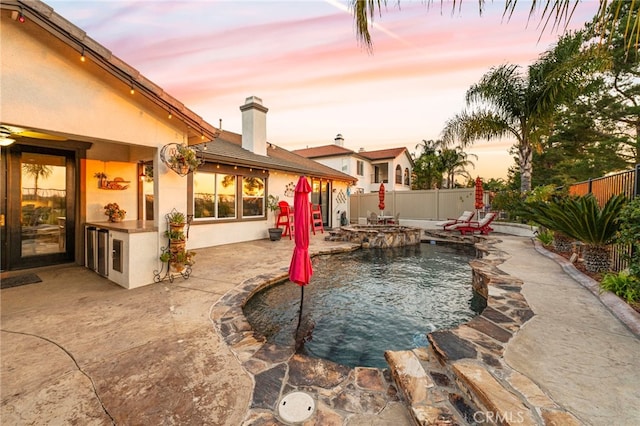32872 Northshire Cir, Temecula, CA 92592 - yard at dusk featuring a fenced backyard, a patio area, and a pool with connected hot tub