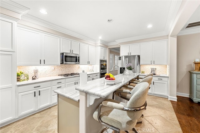 32872 Northshire Cir, Temecula, CA 92592 - kitchen with stainless steel appliances, a kitchen island with sink, recessed lighting, crown molding, and white cabinets