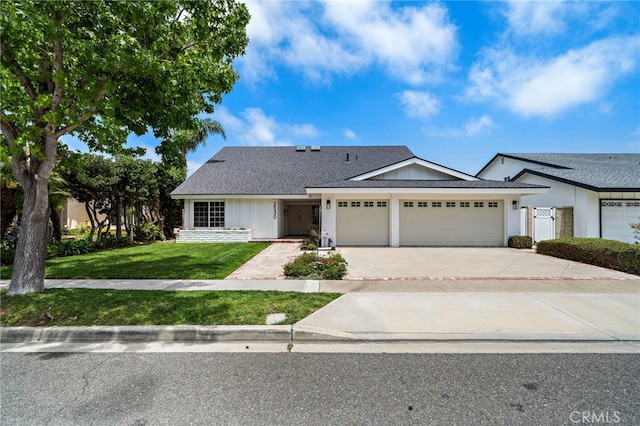 2030 Goldeneye Pl, Costa Mesa, CA 92626 - view of front of house featuring a garage, a front yard, driveway, and board and batten siding
