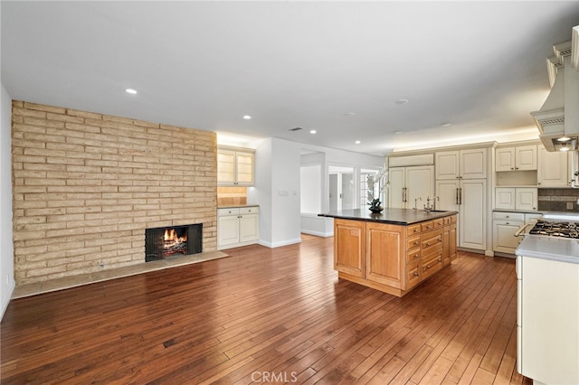 2030 Goldeneye Pl, Costa Mesa, CA 92626 - kitchen with a brick fireplace, wood-type flooring, a kitchen island, wall chimney exhaust hood, and recessed lighting