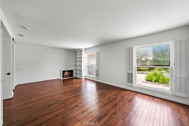 2030 Goldeneye Pl, Costa Mesa, CA 92626 - unfurnished living room with a fireplace, hardwood / wood-style flooring, brick wall, and built in shelves