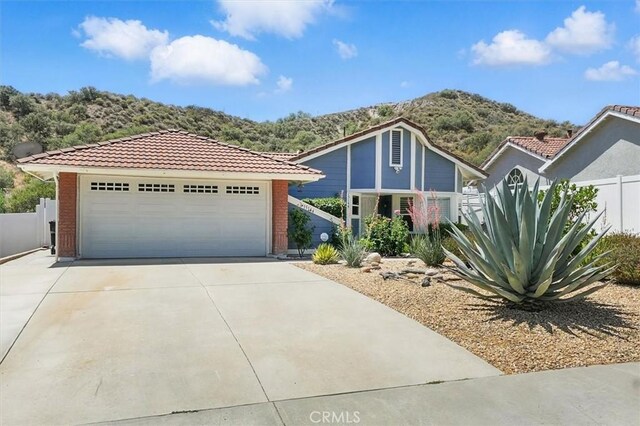 15144 Poppy Meadow St, Canyon Country, CA 91387 - view of front of home featuring a mountain view, a tiled roof, brick siding, and concrete driveway