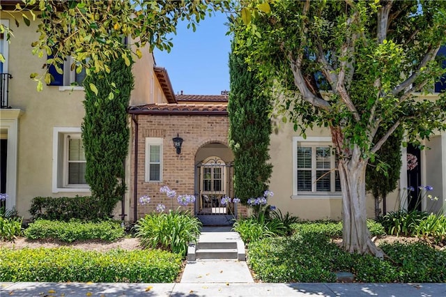 74 Townsend, Irvine, CA 92620 - view of front of property with stucco siding, a tile roof, and brick siding