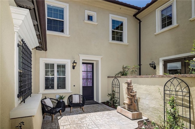 74 Townsend, Irvine, CA 92620 - property entrance featuring stucco siding and a patio area