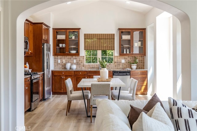 74 Townsend, Irvine, CA 92620 - dining space featuring arched walkways, light wood-type flooring, and vaulted ceiling
