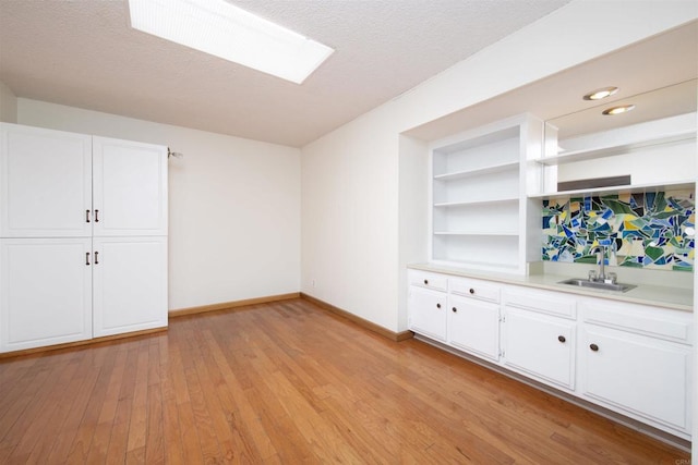 3621 Vista Campana S Unit 11, Oceanside, CA 92057 - bar featuring light wood finished floors, a textured ceiling, a skylight, and built in shelves