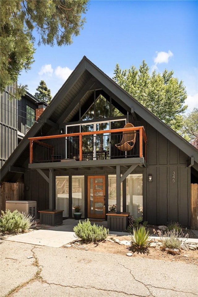 345 Maple Dr, Lake Arrowhead, CA 92352 - back of property featuring board and batten siding, a balcony, and a chimney