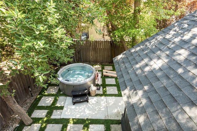 345 Maple Dr, Lake Arrowhead, CA 92352 - exterior view of a hot tub, a fenced backyard, and a shingled roof