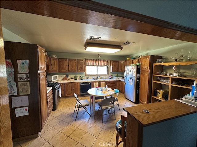 18211 Hercules St, Hesperia, CA 92345 - kitchen featuring appliances with stainless steel finishes, light tile patterned floors, and light countertops