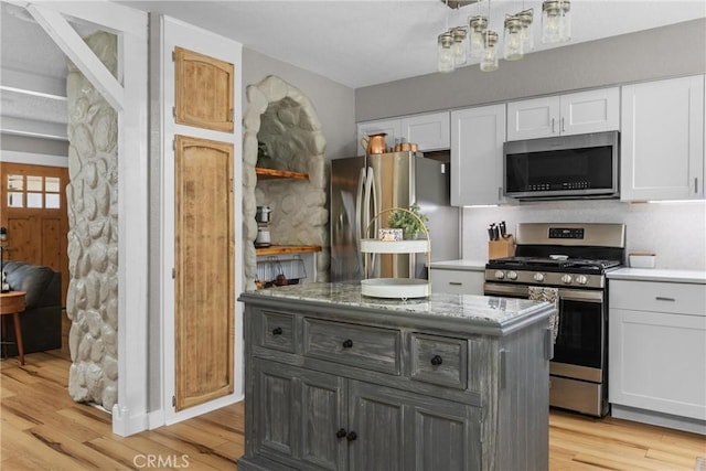 4913 Sparrow Hawk Ln, Paso Robles, CA 93446 - kitchen featuring appliances with stainless steel finishes, white cabinetry, light wood-style flooring, and a kitchen island