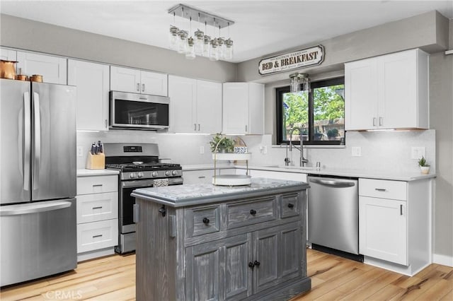 4913 Sparrow Hawk Ln, Paso Robles, CA 93446 - kitchen with stainless steel appliances, white cabinets, light wood-type flooring, and decorative backsplash