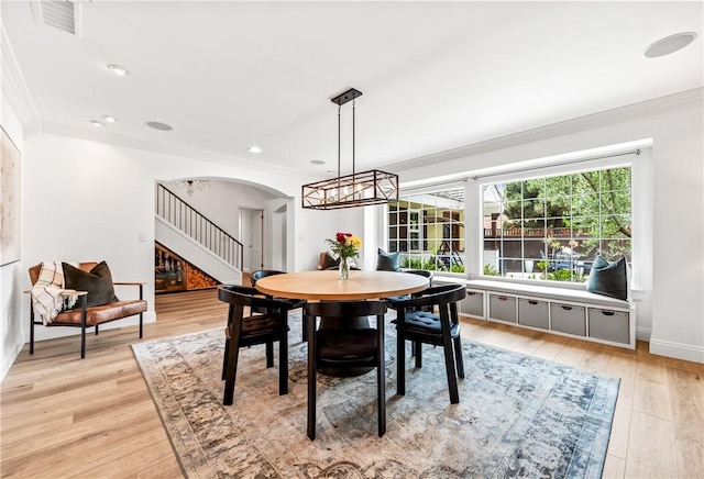 2726 Cardinal Dr, Costa Mesa, CA 92626 - dining area with ornamental molding, stairs, arched walkways, and light wood-style floors