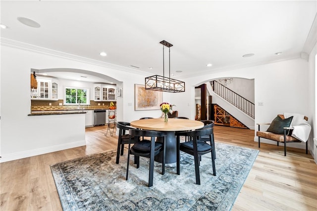 2726 Cardinal Dr, Costa Mesa, CA 92626 - dining area featuring arched walkways, crown molding, stairs, light wood-type flooring, and recessed lighting