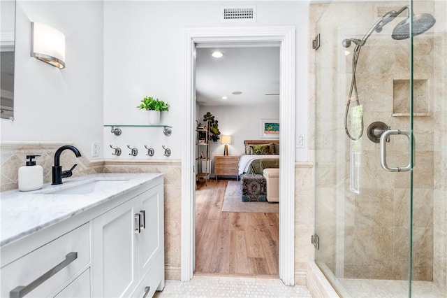 2726 Cardinal Dr, Costa Mesa, CA 92626 - ensuite bathroom with vanity, a stall shower, tile walls, a wainscoted wall, and recessed lighting