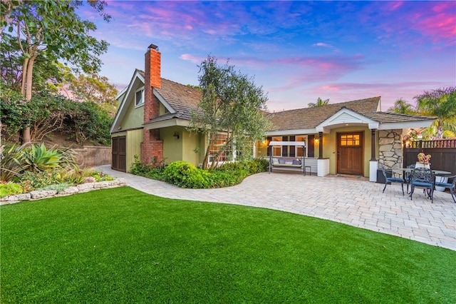 2726 Cardinal Dr, Costa Mesa, CA 92626 - rear view of house with a chimney, a patio, stucco siding, and stone siding