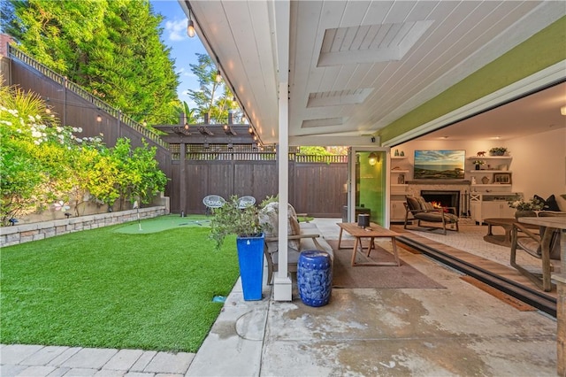 2726 Cardinal Dr, Costa Mesa, CA 92626 - fenced backyard with a putting area, a lit fireplace, and a patio area