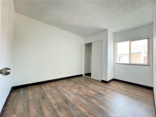 309 Whispering Pine Ln, La Puente, CA 91744 - unfurnished bedroom with wood-type flooring, a textured ceiling, and a closet